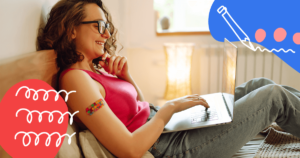 a woman sitting on her bed reading from her computer